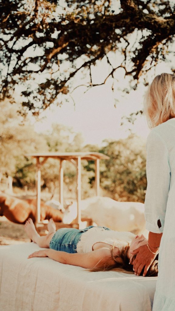 Frau auf einer Liege im sanften Abendlicht bei den Pferden. Sinnbild für intuitive Energiearbeit im Alentejo