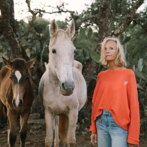 Unsicherheit in der Zukunft. Frau mit fragendem Blick bei zwei Pferden in Portugal. Sinnbild für Begleitung durch Beziehungskrisen