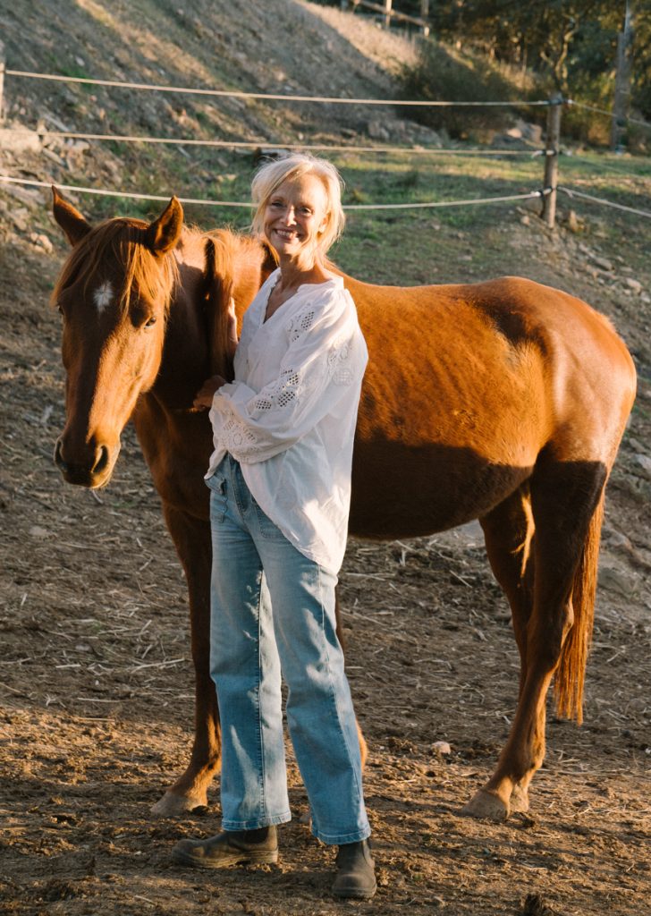 Frau mit Fuchsfarbenem Pferd in der Abendsonne. Sinnbild für neuen Mut bei Retreat in Portugal mit Pferden